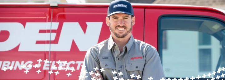 HVAC technician standing in front of a service van during a residential heating and cooling service call.