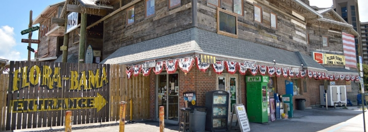 Flora-Bama beachfront bar and entertainment venue with patriotic decorations and rustic wood exterior.