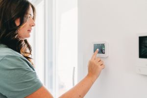 thermostat-adjustments-by-woman-with-dark-hair
