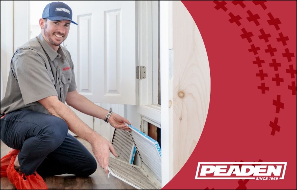 A Peaden HVAC technician replacing an air filter in a residential home