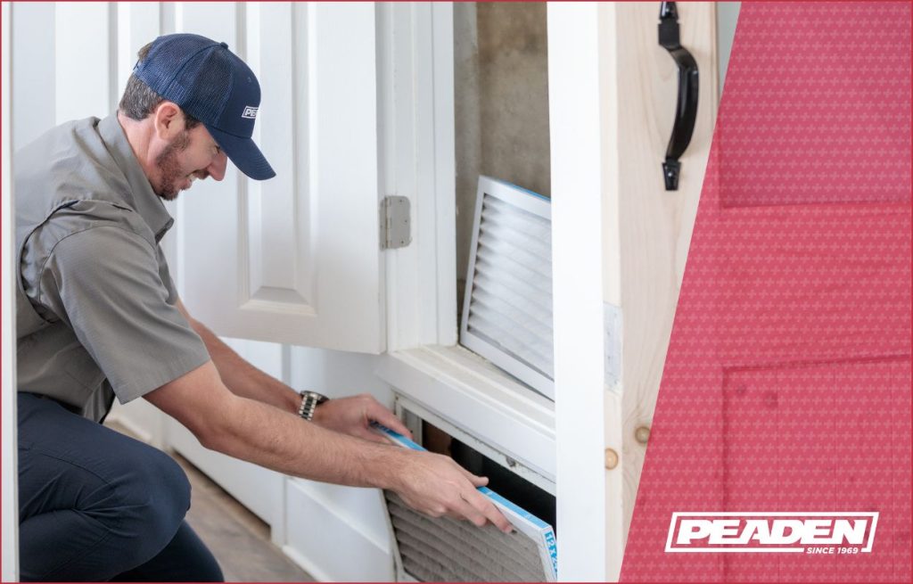 HVAC tech installing an air filter.