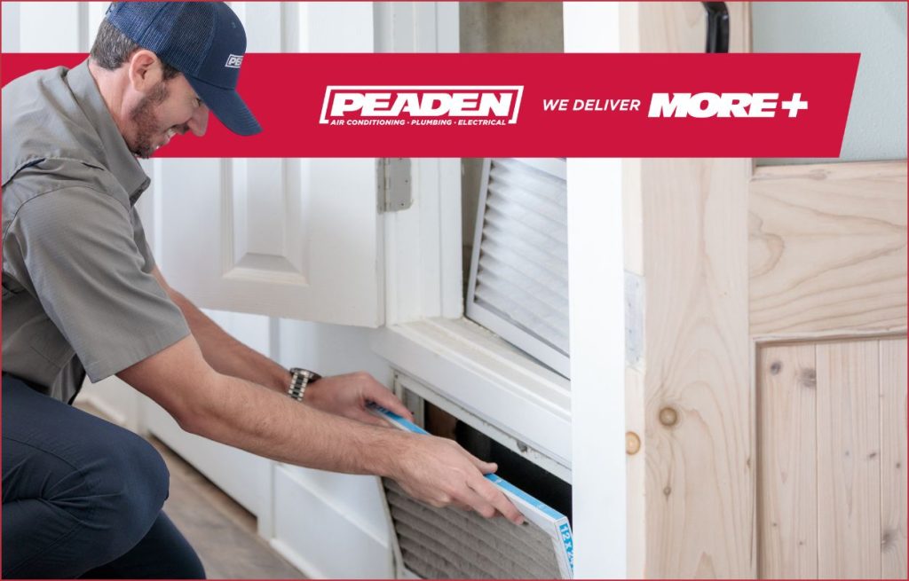 A HVAC technician changing an air filter.