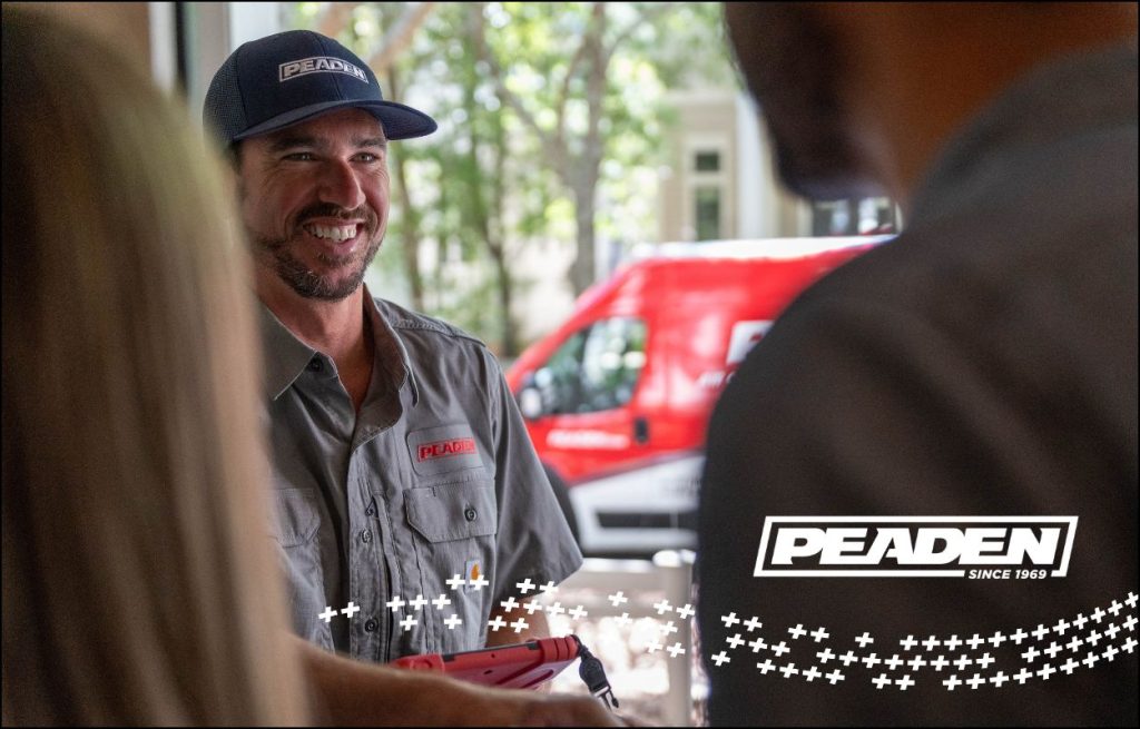 An HVAC technician shaking hands with the homeowner at the front door.