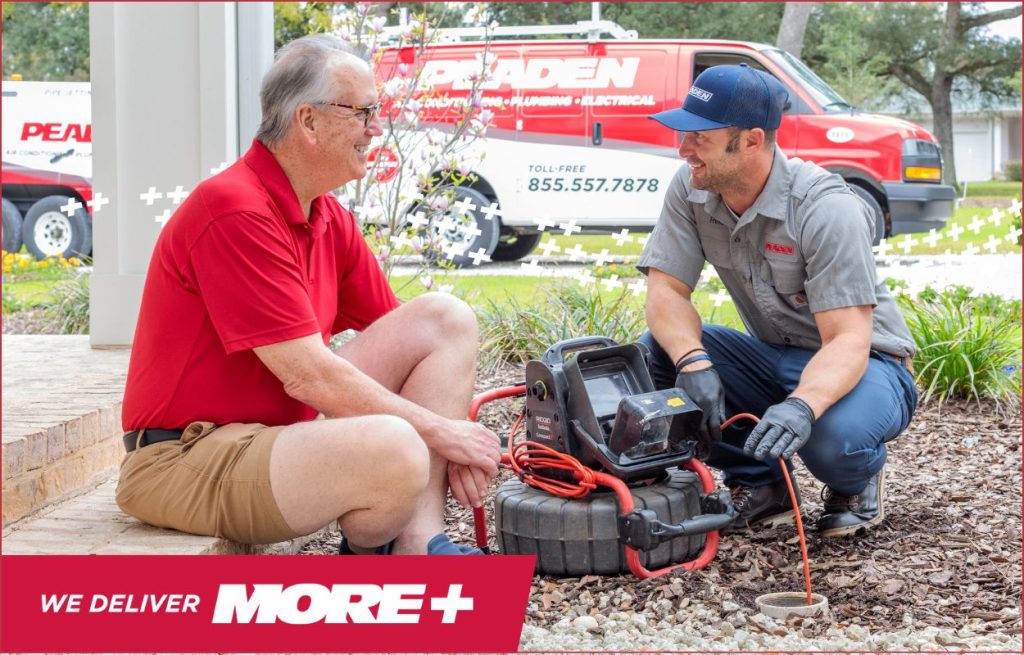 A plumber using a drain camera with the homeowner.