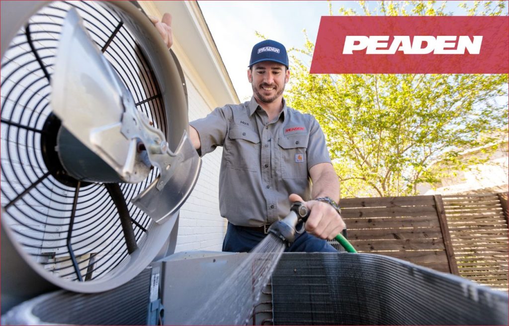 A Peaden HVAC tech cleaning a AC unit.