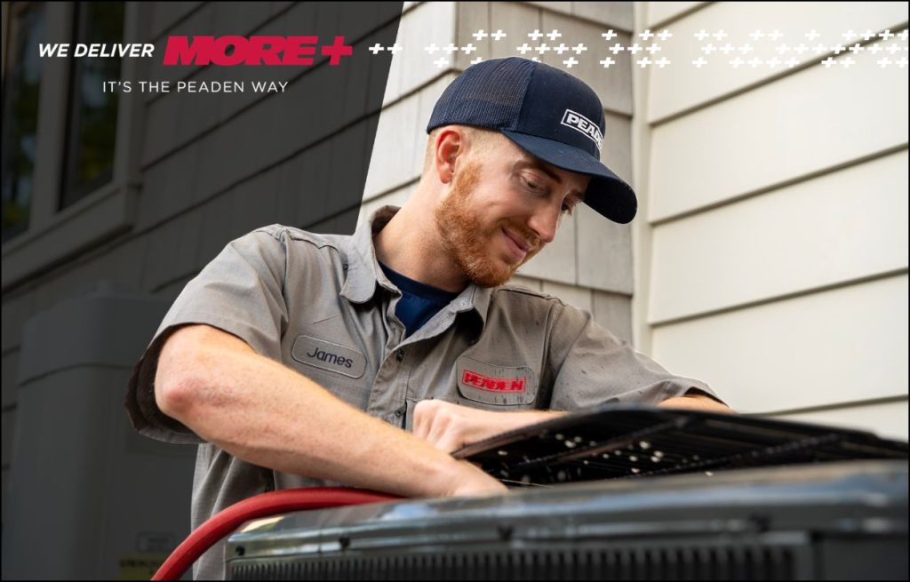 A Peaden HVAC tech cleaning an AC unit.