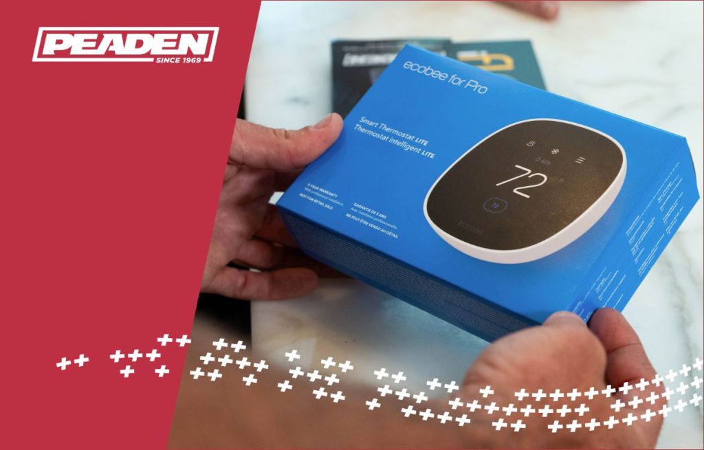 A HVAC tech showing a smart thermostat.