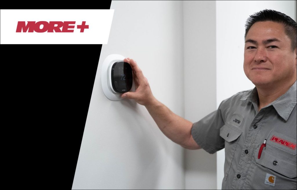 A Peaden HVAC tech adjusting a smart thermometer