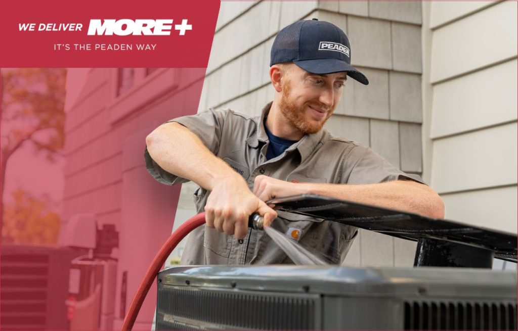 A Peaden HVAC tech cleaning an AC unit.