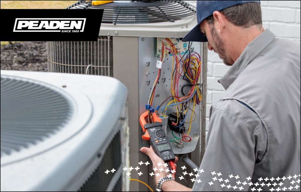 A Peaden HVAC tech servicing an AC unit