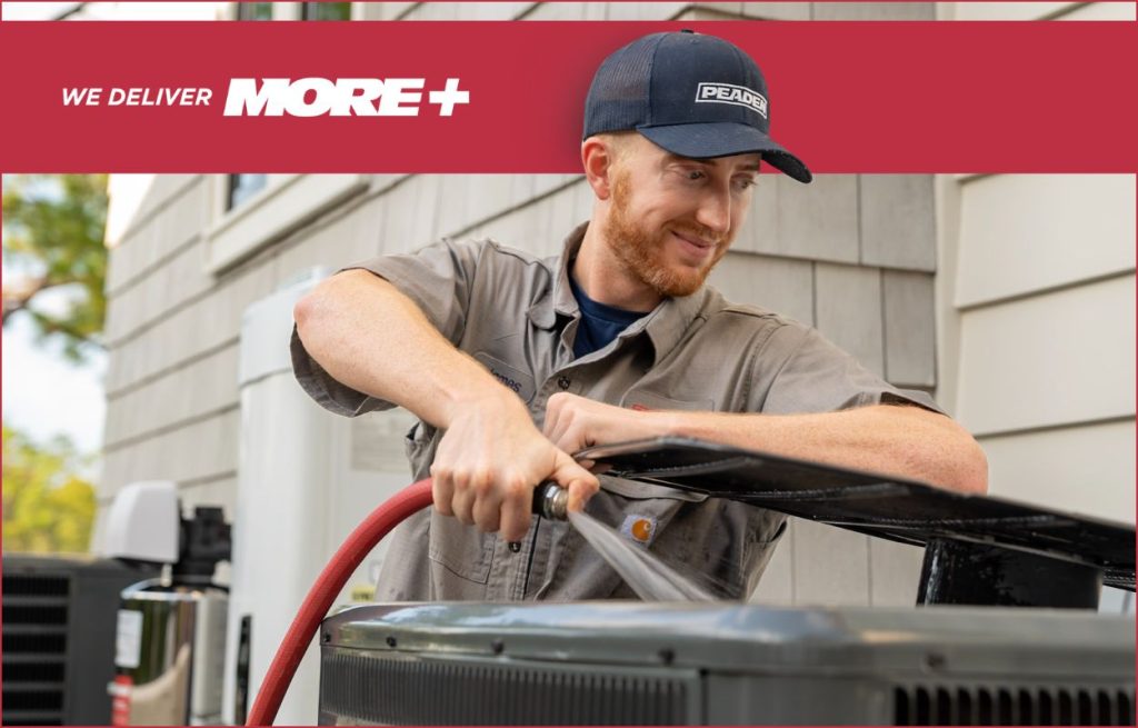 A Peaden HVAC tech cleaning an AC unit.
