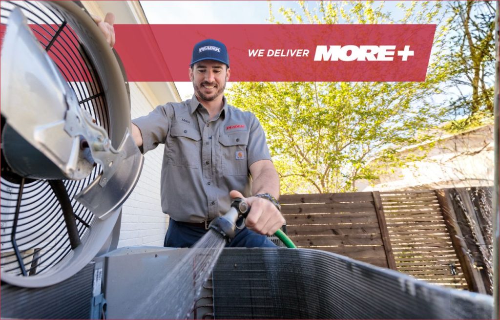 A Peaden HVAC tech cleaning an AC unit.