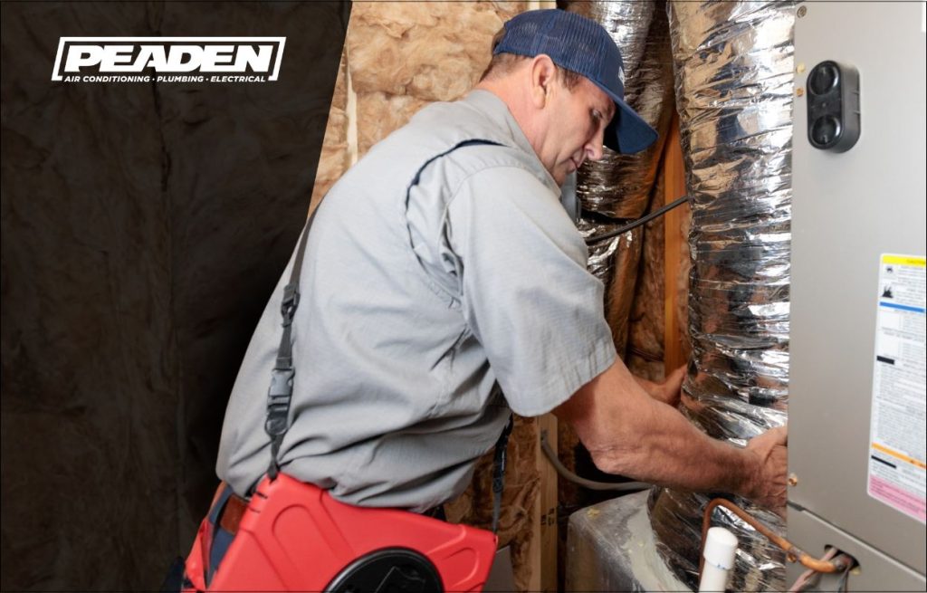 A Peaden HVAC tech inspecting ductwork