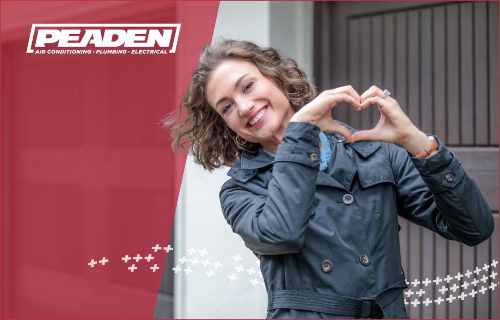 A satisfied Peaden customer make a heart sign.