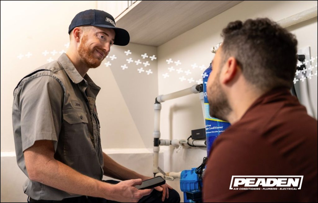 A Peaden plumber explaining whole home water treatment to a client.