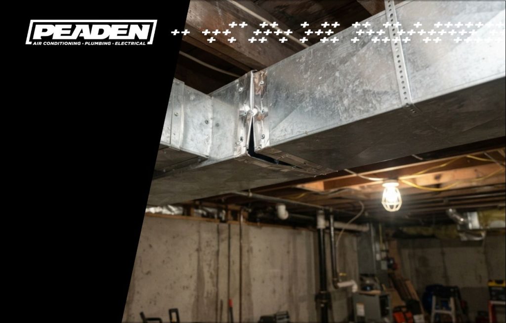 Square metal ductwork in basement ceiling with slight gap at joint