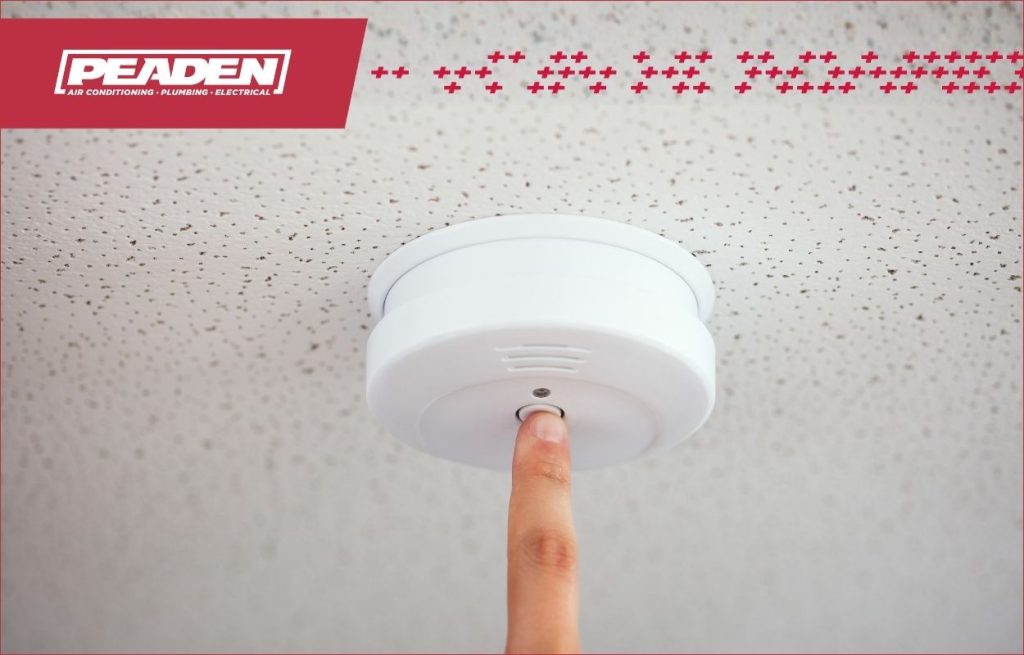 A homeowner testing their smoke detector.