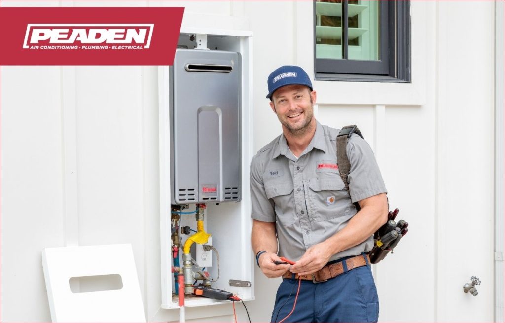 A Peaden plumber servicing a water heater.