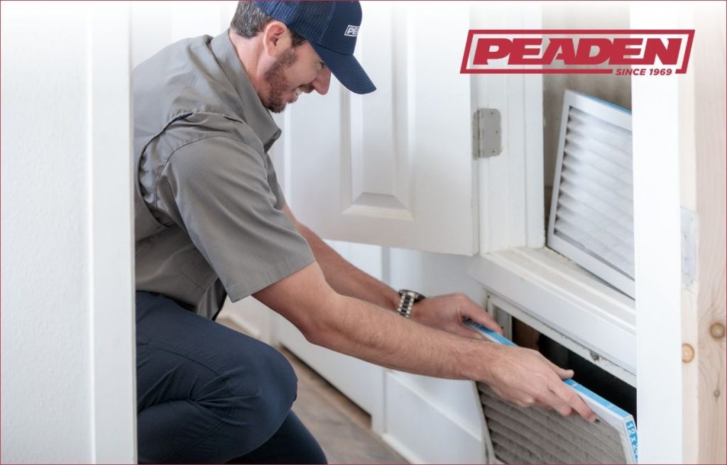 A Peaden HVAC tech changing an air filter