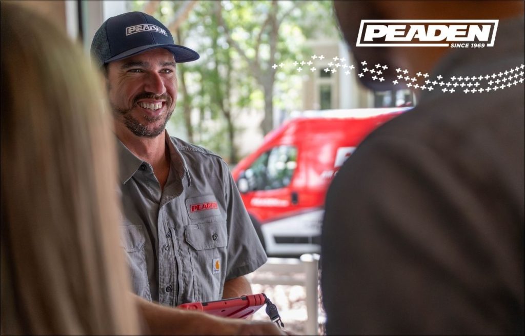 A Peaden HVAC tech greeting homeowners at the door during a service call.
